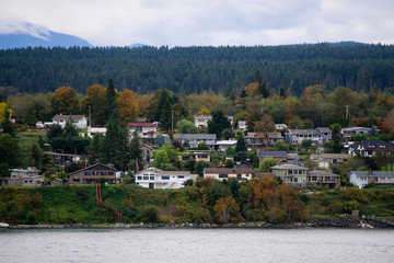 Campbell River, Vancouver Island, British Columbia, Canada. Beautiful view of residential homes on the ocean shore during a cloudy evening.