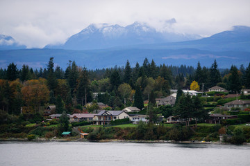 Campbell River, Vancouver Island, British Columbia, Canada. Beautiful view of residential homes on the ocean shore during a cloudy evening.