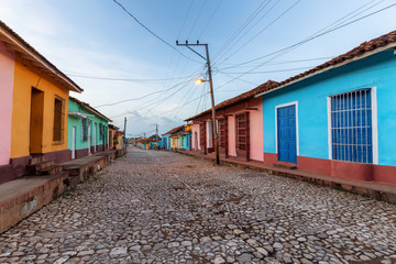 Street view of a Residential neighborhood in a small Cuban Town during a cloudy and sunny sunrise. Taken in Trinidad, Cuba.