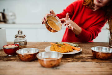 Beautiful red haired middle-aged woman cooking healthy food to stay fit and be in good healht....