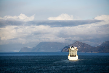 Glacier Bay National Park and Preserve, Alaska, USA. Big White Cruise Ship is cuising in the Ocean during a cloudy and sunny morning in fall season.