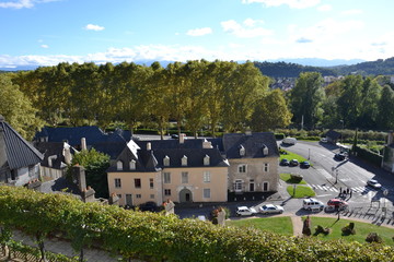 picturesque old houses at the foot of the castle of Pau and Pyrenees in the distance on the horizon