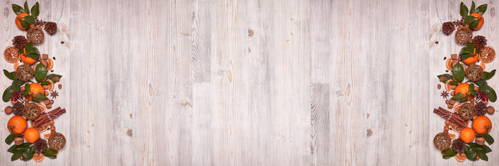 Christmas and New Year background with mandarins, nuts, spice and fir ornaments. Extra wide panorama banner background