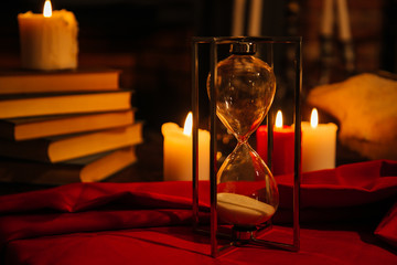 Magic composition with skull, candles, magic book and hourglass. Halloween and the occult concept...
