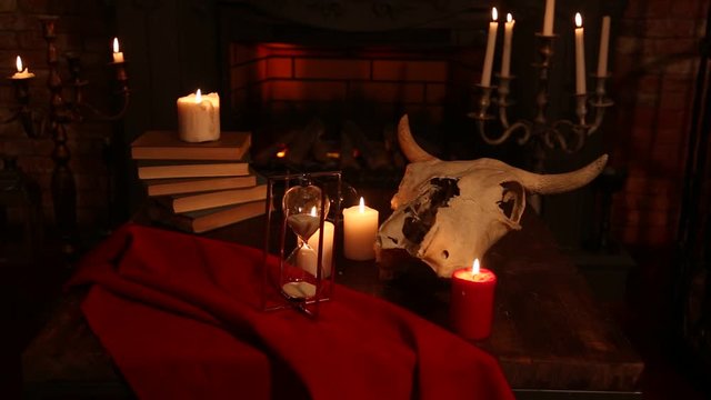 Witchcraft composition with skull, candles, magic book. Halloween and occult concept, black magic ritual.