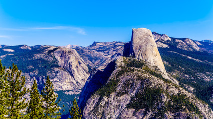 View from Glacier Point at the end of Glacier Point Road of the Sierra Nevada high country, with the curved tooth of the famous Half Dome in the foreground in Yosemite National Park, California, USA