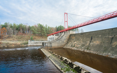 Linnamäe hydroelectric power station  situated in the lower stretch of the Jägala River. Red metallic bridge construction with viewing platform , concrete dam. Estonia, North Europe