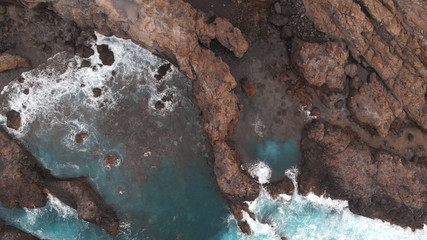 The natural pools of the island of Tenerife are a secret place. Aerial view. Cliffs of frozen lava and turquoise ocean