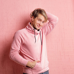 Happy and smiling young man in casual clothes looks at the camera, portrait with real emotions