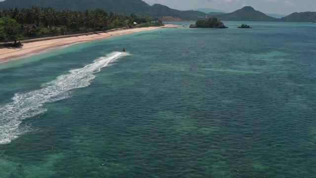 Top aerial view of jet ski racing on a crystal clear water. Extreme enjoying summer vacation. People are playing a water scooter in open sea waters. Watercraft adventure fresh day in summer holiday.