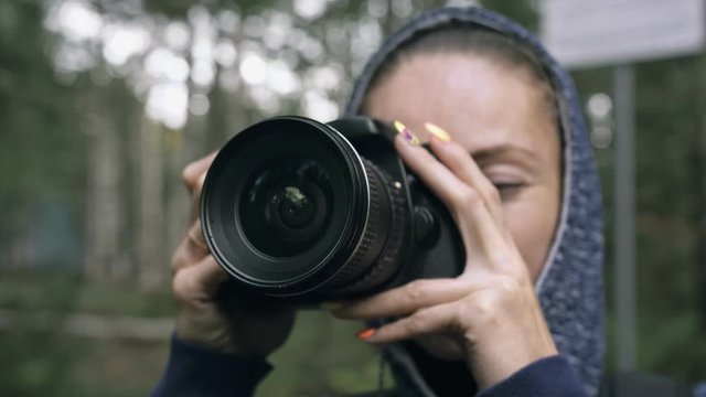 Traveler photographing scenic view in forest. One caucasian woman shooting close up look. Girl take photo video on dslr mirrorless camera. Professional photographer travel with backpack. Outdoor.