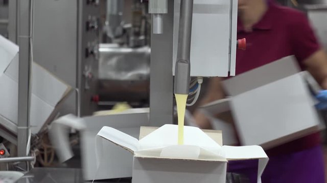 The process of packing butter into boxes. Closeup view of packing machine