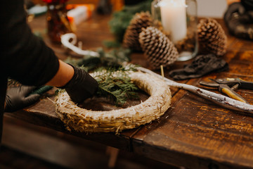 Christmas handmade wreath in young womans hands