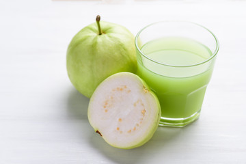 Green guava fruit and guava juice in glass on white background, high vitamin C healthy drink