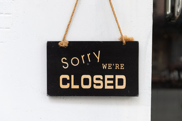 sorry we are closed sign hanging outside a restaurant, store, office or other