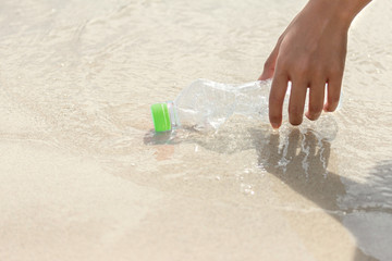 hand pick Plastic Bottle to Recycling Garbage collection with the beach