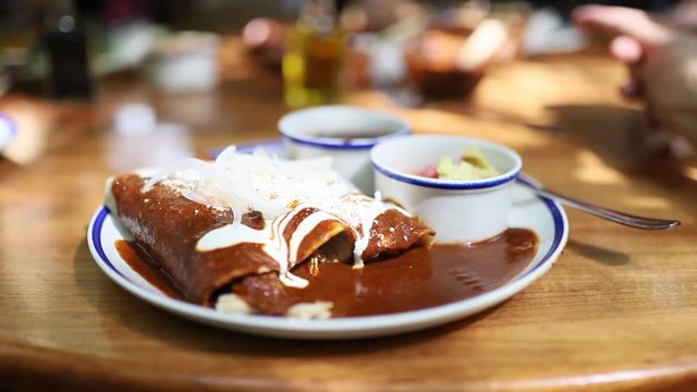 Shot Spinning Around Mexican Dish Enchiladas on the Table of a Restaurant