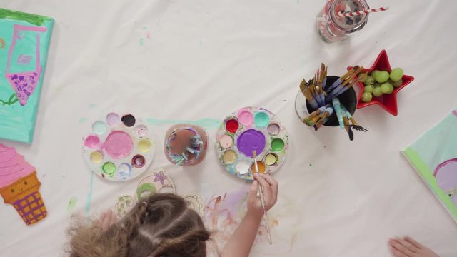 Flat lay. Little girls are painting on canvas on July 4th party.