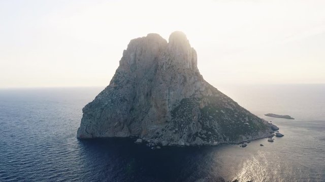 Drone Shot of Towering Cliff in Ibiza Surrounded by Still Ocean Waters