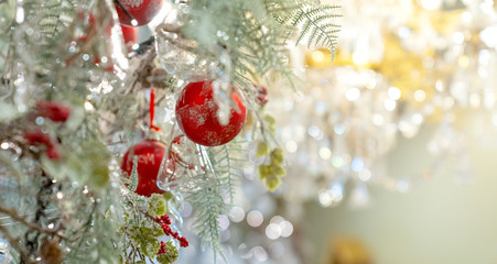 Beautiful red and gold Christmas Bauble hanging on decorated Christmas tree festive christmas eve background concept