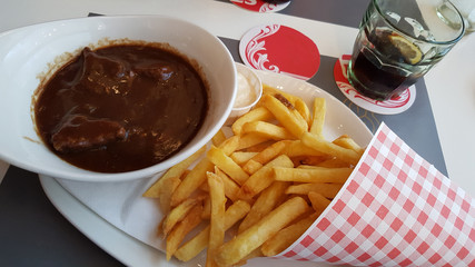 french fries with beef stew served on a plate