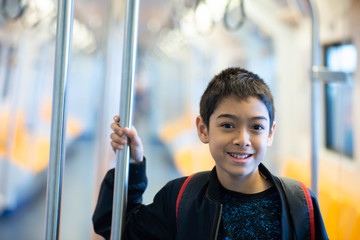 Little boy buying electric ticket and walking in the public sky train station with family