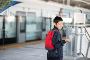 Fototapeta premium Little boy buying electric ticket and walking in the public sky train station with family