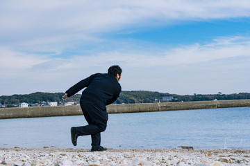 写真素材：水切りをする男　石飛ばし