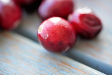 Macro view on group of bright glossy red cranberries on wooden surface