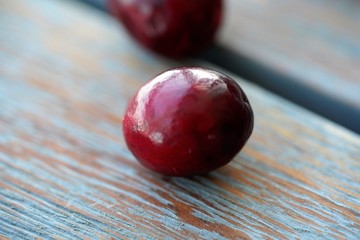 Macro view on group of bright glossy red cranberries on wooden surface