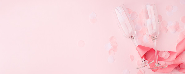 Valentines day greeting card. Empty Wine glasses for wine and ribbon on a soft light pink background. Flat lay, top view, copy space, minimal february  romance concept, banner