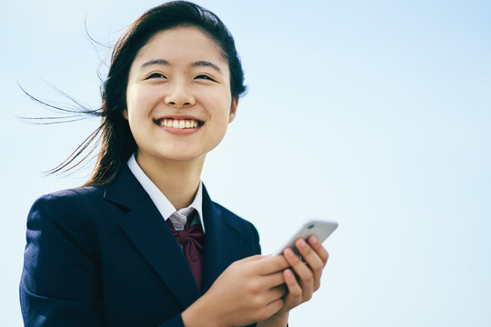 スマホを見る女子高校生