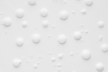 White liquid paint texture with random bubbles and stains as modern abstract background.
