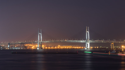 Naklejka premium 横浜港を行き来する船の光跡とベイブリッジ