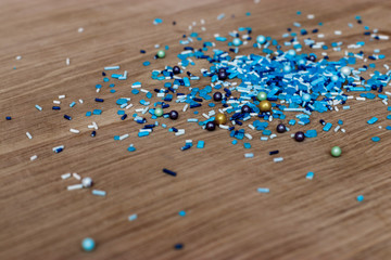 Bright confectionery decoration of small blue details, against the background of a white oak kitchen board. New Year's decor for cakes and pastries.