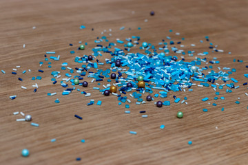 Bright confectionery decoration of small blue details, against the background of a white oak kitchen board. New Year's decor for cakes and pastries.