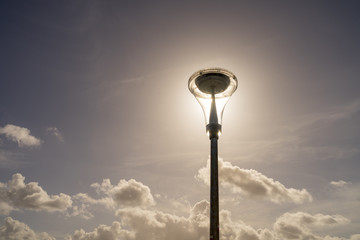 Detail of the decorative street lantern on the coastal road near Quiberville, Seine-Maritime department in northern France.  Bright sunny autumn day, sun shines through the glass parts of the lamp.
