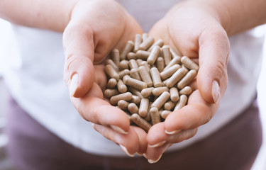 Woman holding colored pills in her hands