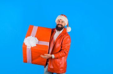 Santa christmas man holds gift present. Delivery christmas present. Delivery service. Christmas gift. Businessman in Santa hat holds gift. Man holds big gift box. Happy man with christmas present box.