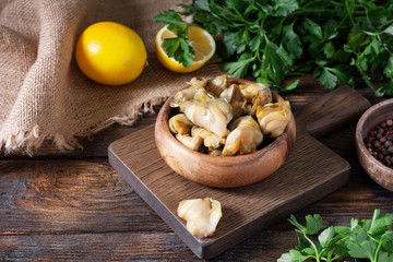 Meat rapan in a wooden bowl on a wooden table. Seafood, meat rapana	