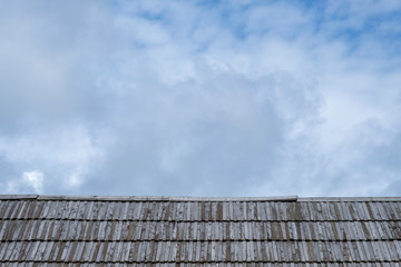 Obraz premium Wooden roof with cloudy sky in background.