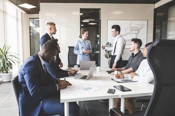 A team of young businessmen working and communicating together in an office. Corporate businessteam and manager in a meeting