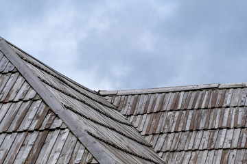 Fototapeta na wymiar Wooden roof with cloudy sky in background.