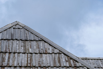 Wooden roof with cloudy sky in background.