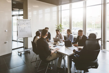 A team of young businessmen working and communicating together in an office. Corporate businessteam...