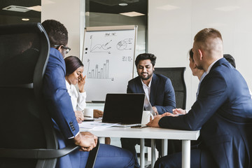 A team of young businessmen working and communicating together in an office. Corporate businessteam and manager in a meeting.