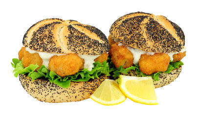 Battered cod fish nugget sandwiches with tartare sauce and lettuce isolated on a white background