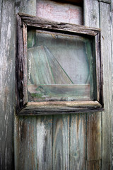 Dilapidated boarded up rotten timber window on derelict building awaiting demolition
