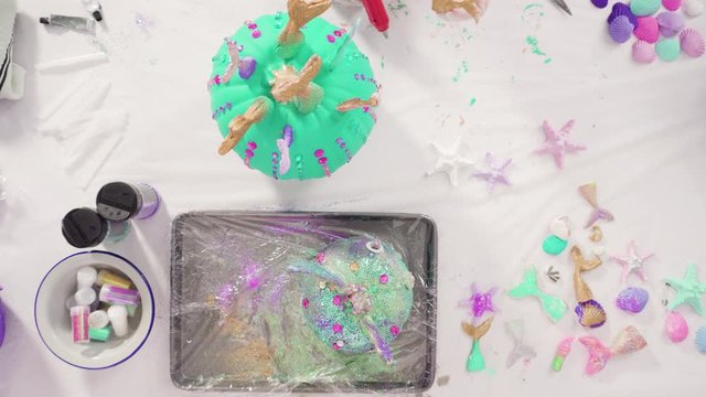 Flat lay. Step by step. Decorating art pumpkins with rhinestones, mermaid tails, and seashells in mermaid theme for Halloween.