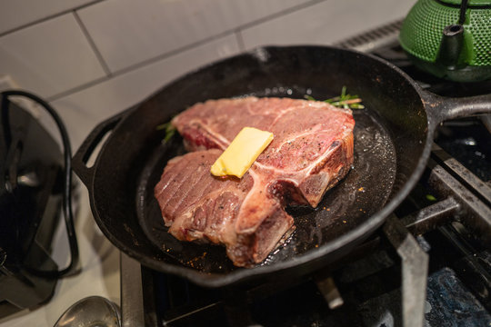 A reverse sear steak is cooked in a pan with butter